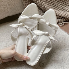 Cream pointed toe mules with a delicate bow detail