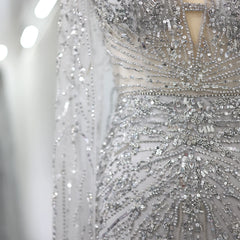  Close-up of the cape detailing and V-neckline on the silver-gray mermaid gown. Golden Atelier 3