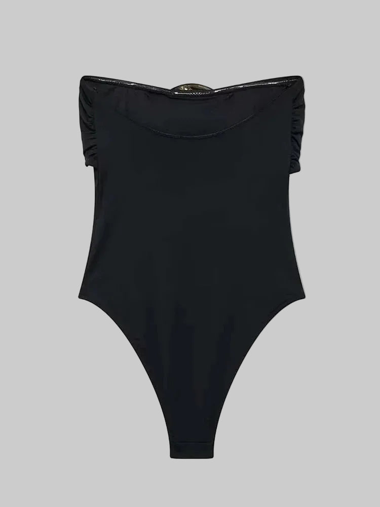 Black swimsuit with ruffled straps on a gray background
