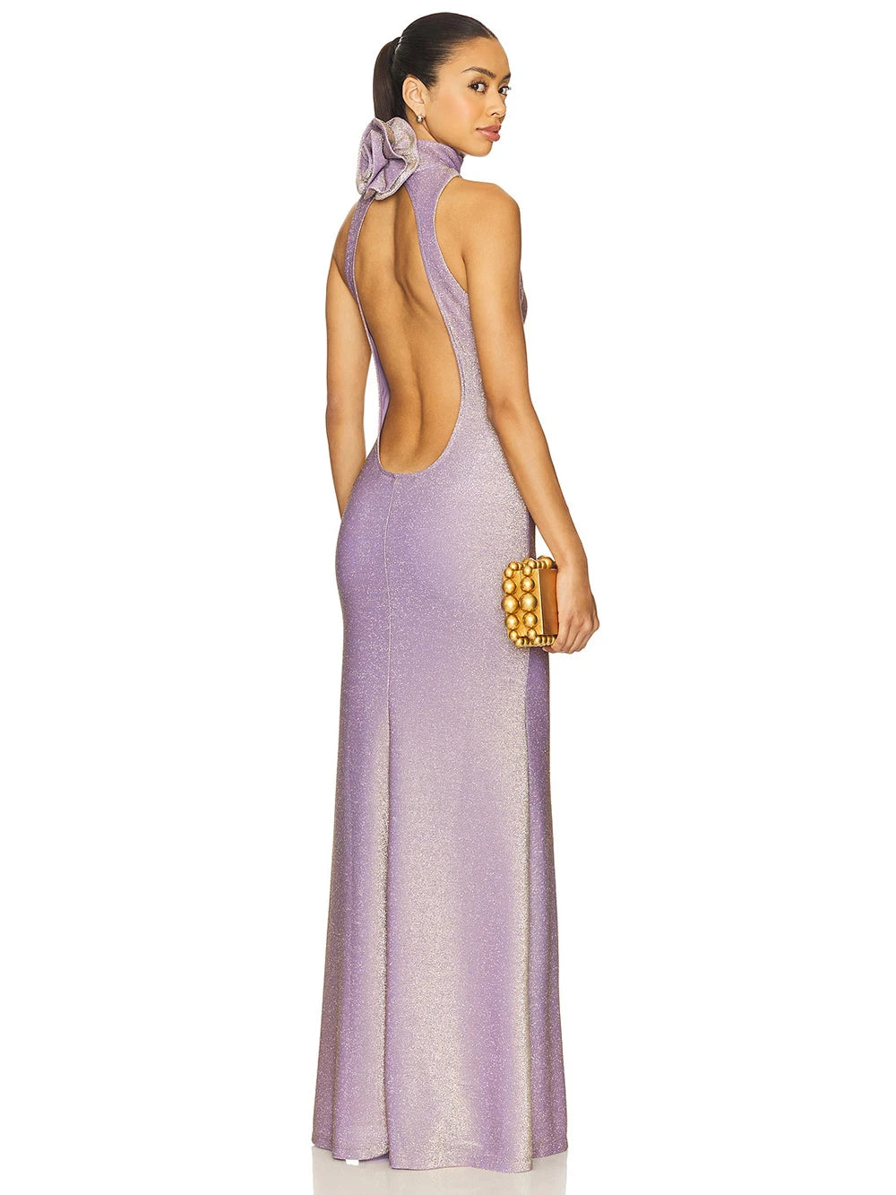 Woman wearing a purple evening gown with a gold clutch on a white background