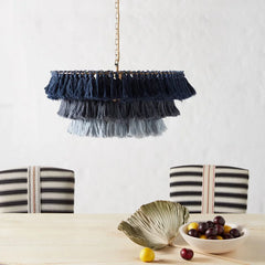 A dining room illuminated by a Fela Tassel Chandelier, creating a cozy and inviting atmosphere. Blue A