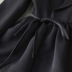 Close-up of a black fabric with a tie detail