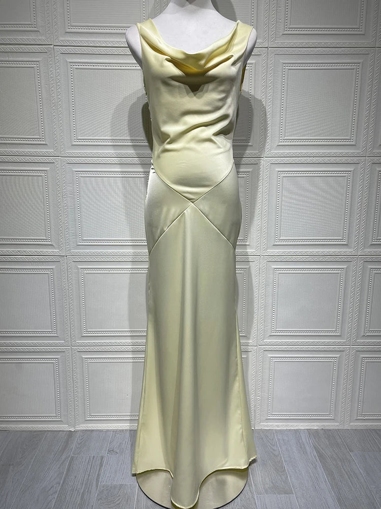 Light green evening gown on a mannequin against a white paneled wall.