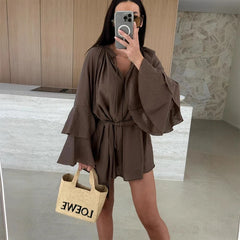 Woman taking a mirror selfie wearing a brown dress in a kitchen.