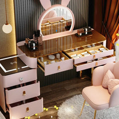 Pink vanity table with mirror and drawers in a room setting