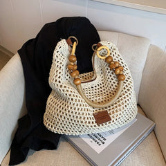 Woven handbag with wooden handles on a couch
