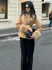 Woman wearing a tan coat with fur trim on a city street.