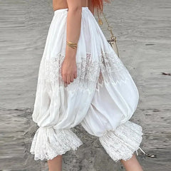 Person wearing a white lace dress on a wooden floor.