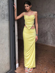 Woman wearing yellow two-piece V-neck party set with sleeveless crop top and slim ankle-length skirt — bright summer outfit for carnivals or events.