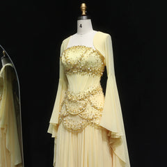 Beige evening gown with gold embellishments on a mannequin against a black background