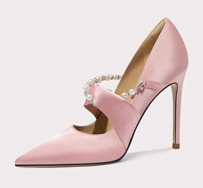 Pink high-heeled shoe with decorative elements on a white background