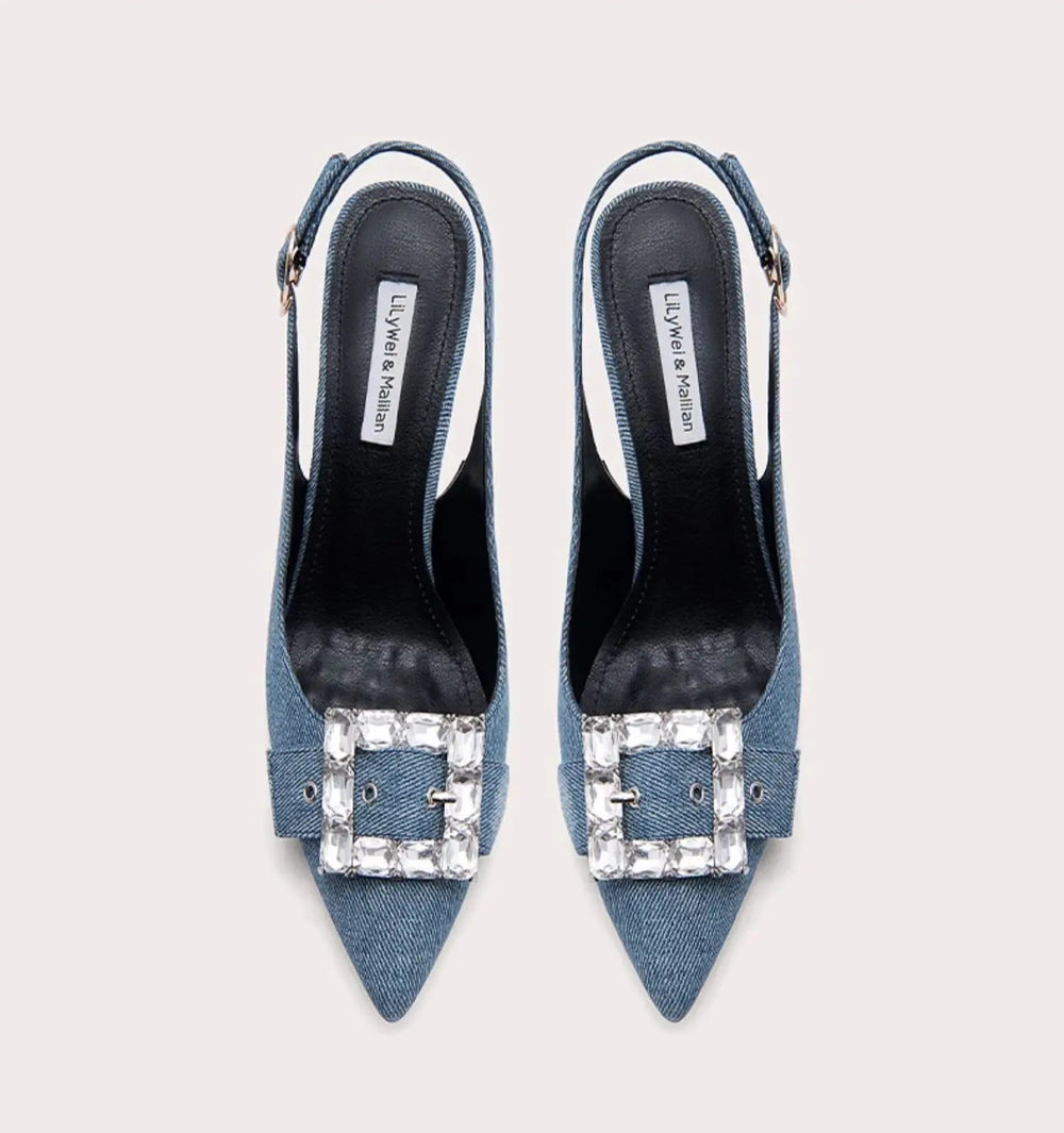 Blue high-heeled shoes with embellished buckles on a light gray background