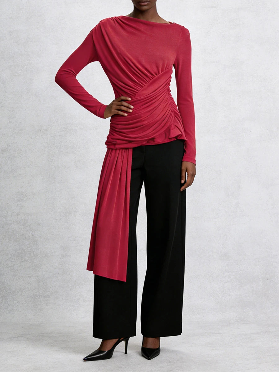 Person wearing a red long-sleeve top and black pants on a white background