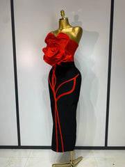 Side view of black strapless sheath dress with red floral applique and red trim