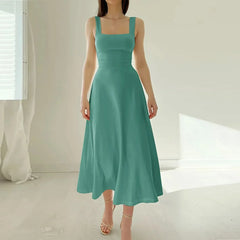 Woman wearing a teal dress in a minimalistic setting