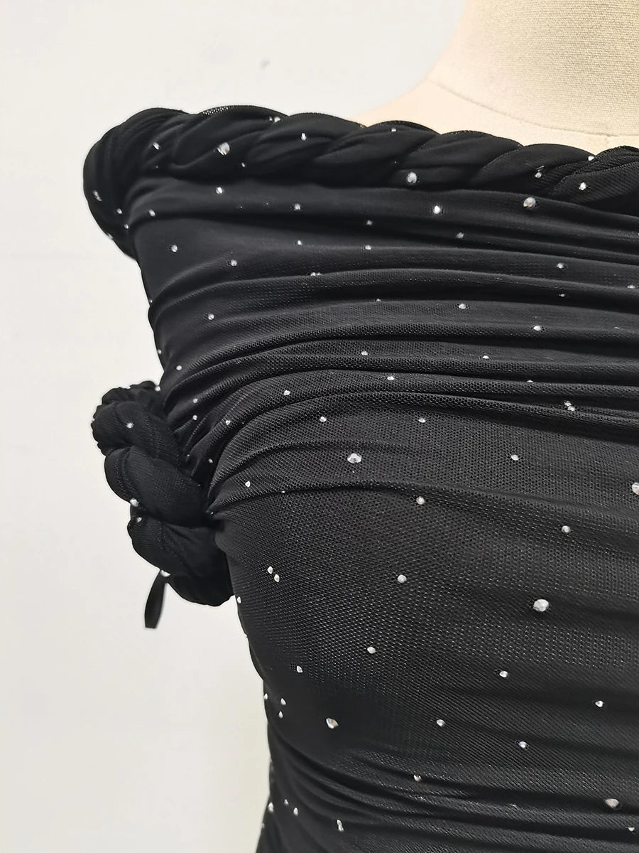 Black dress with silver embellishments on a mannequin against a white background