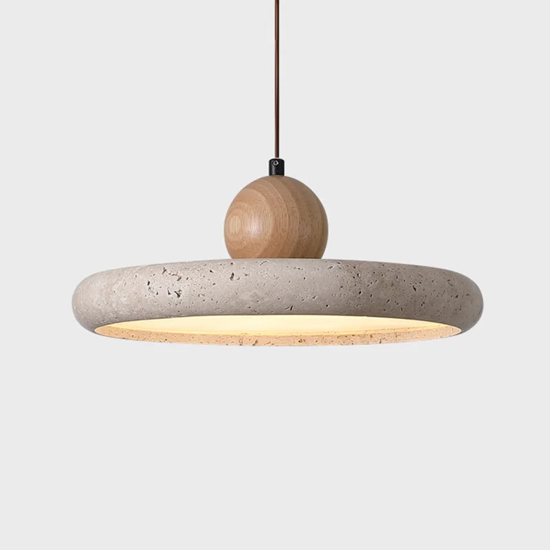 Close-up of a natural stone pendant light showcasing the unique texture and veining of the travertine. A