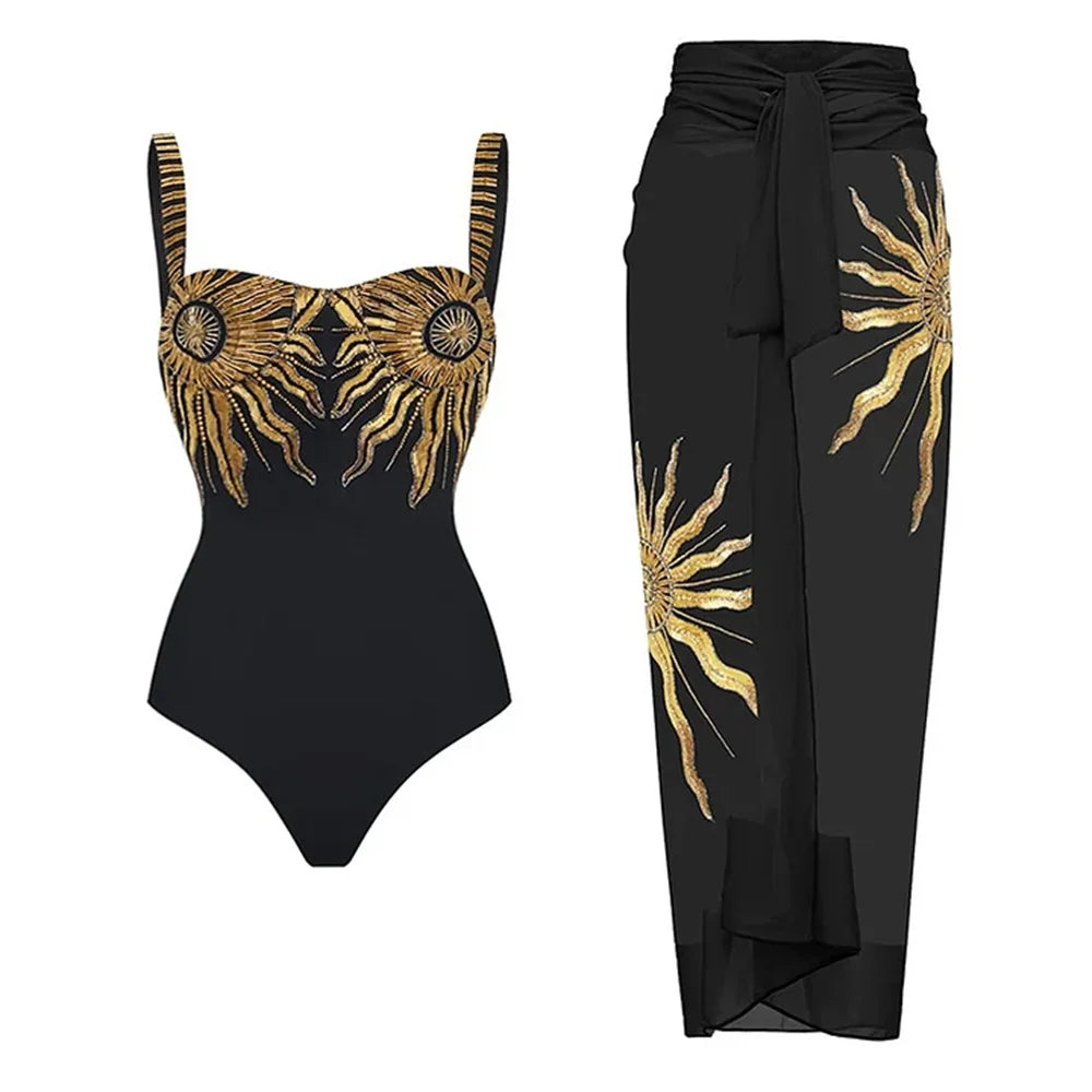 Black one-piece swimsuit with gold sun embroidery and matching black sarong.