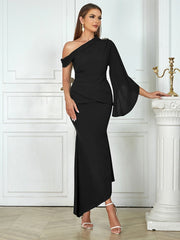 Woman wearing a black one-shoulder dress in an elegant interior setting.