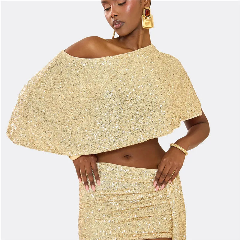 Woman wearing a gold sequin cape and skirt on a white background