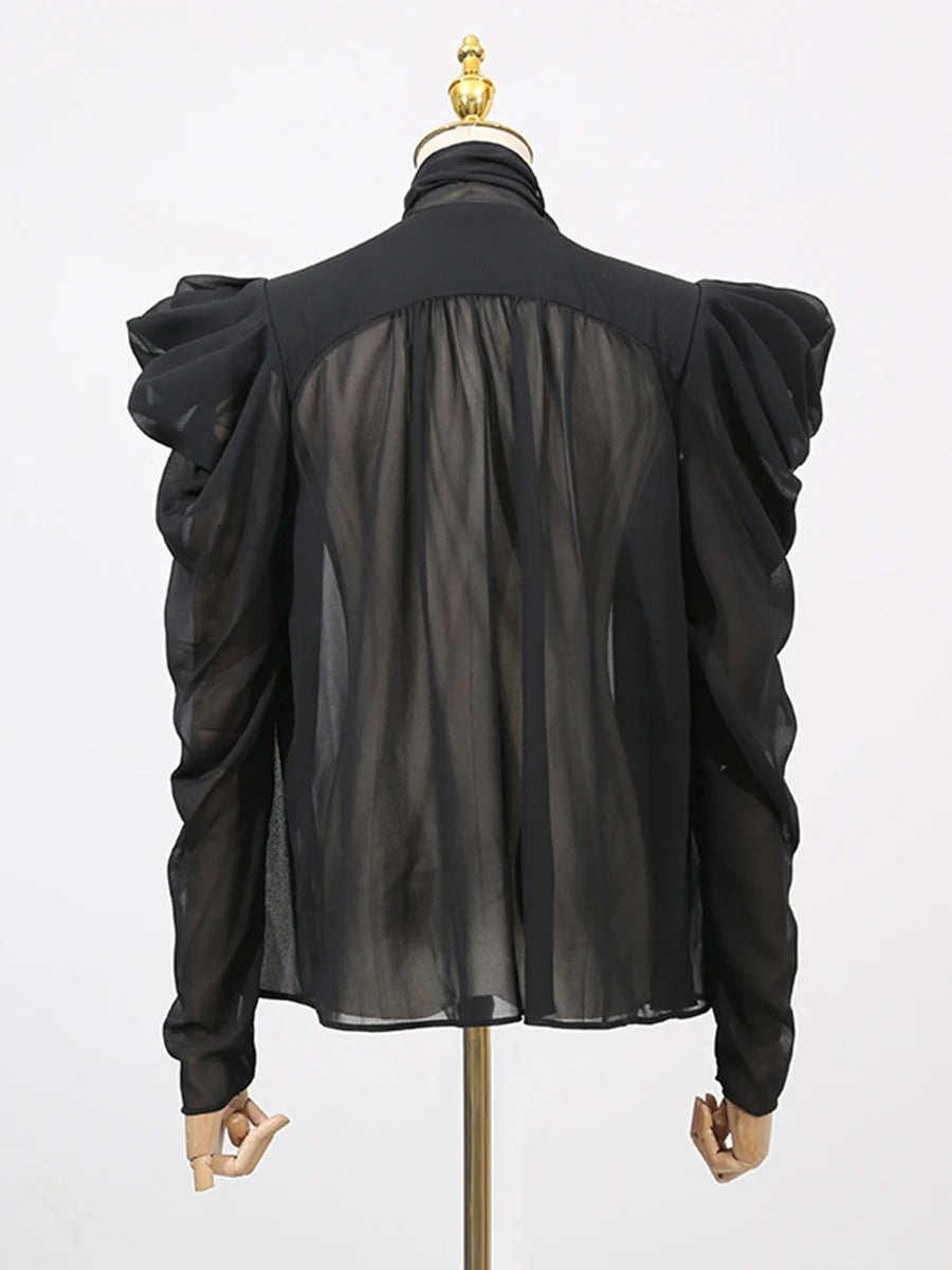 Black sheer blouse on a mannequin with a white background