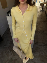 Woman wearing a yellow ribbed dress with long sleeves indoors.