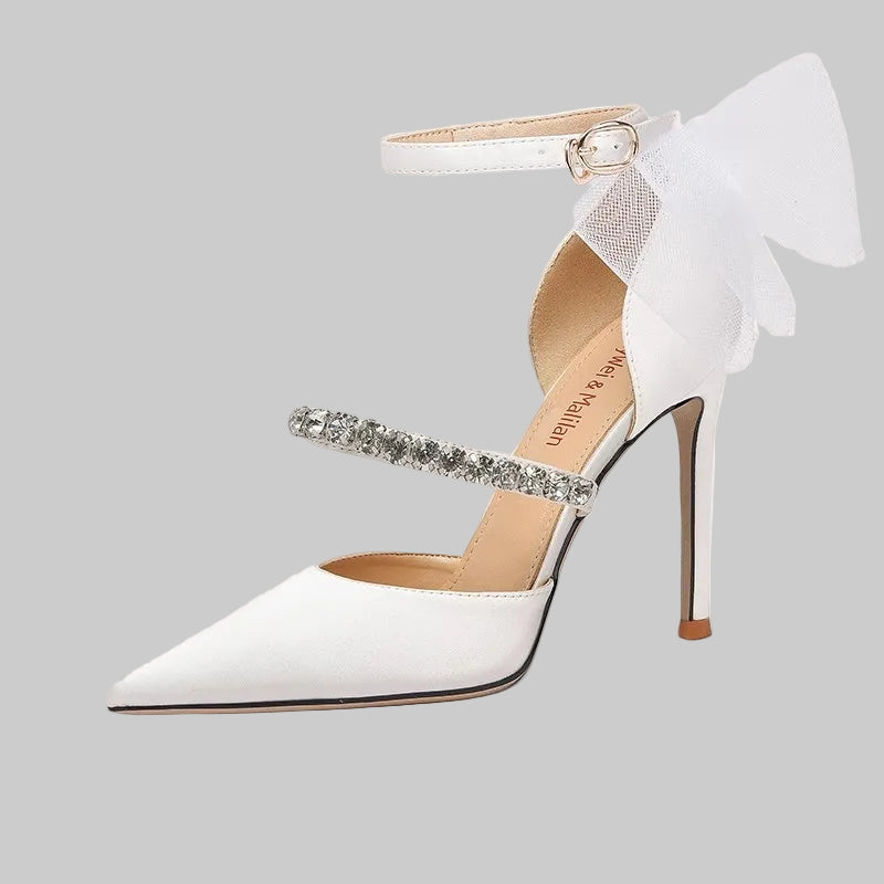 White high-heeled shoe with a decorative strap on a white background