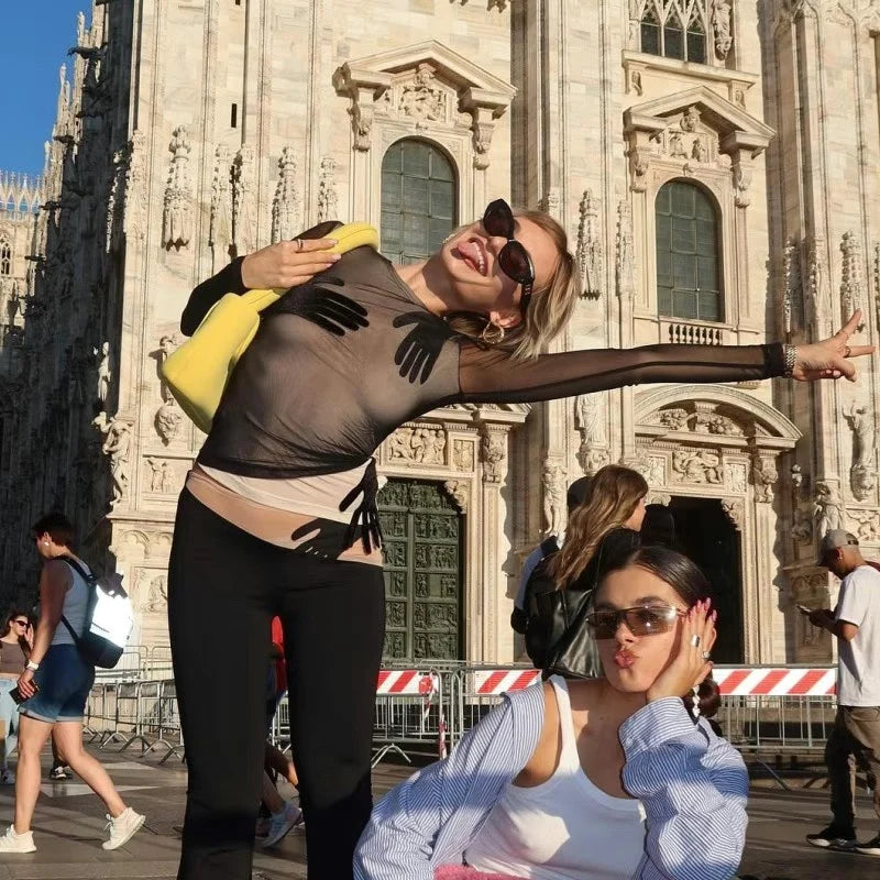 Two women posing in front of a large architectural building, possibly a cathedral.