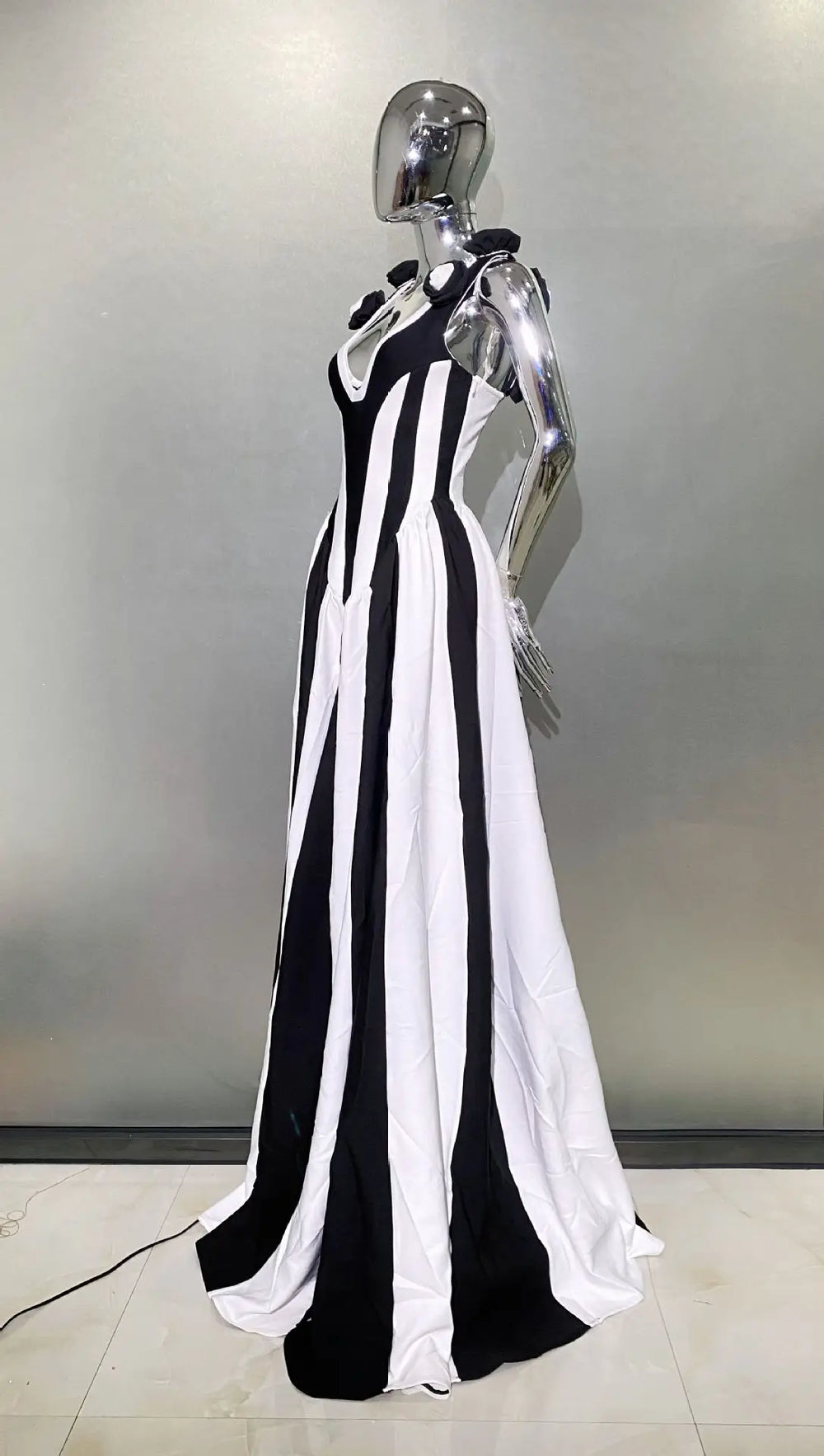 Mannequin wearing a black and white striped dress against a neutral background