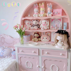 Pink toy shelf with various plush toys and decorative items in a room.