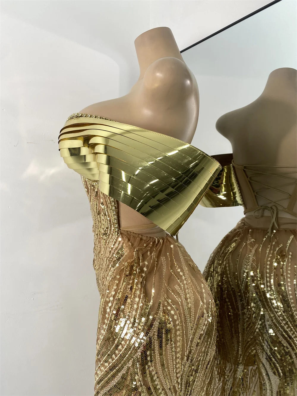 Gold sequin dress on a mannequin with a plain background