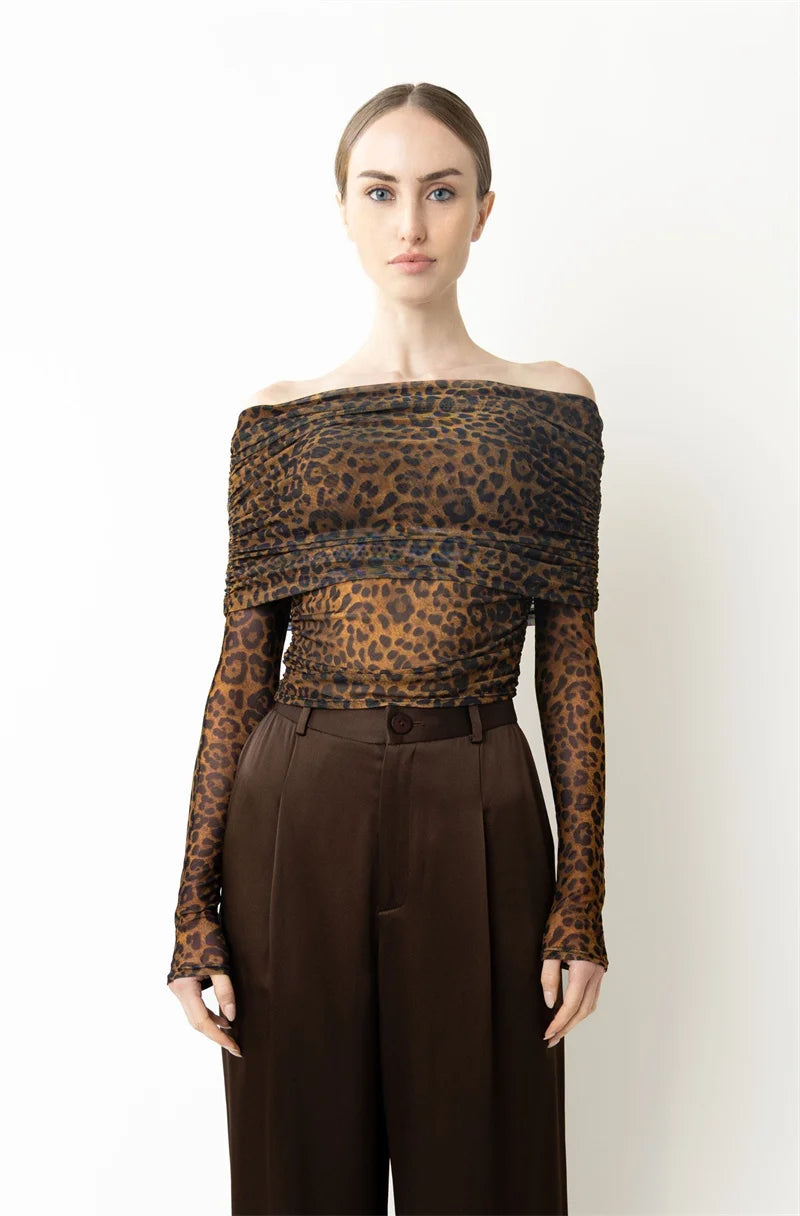 Woman wearing a leopard print off-shoulder top and brown pants 