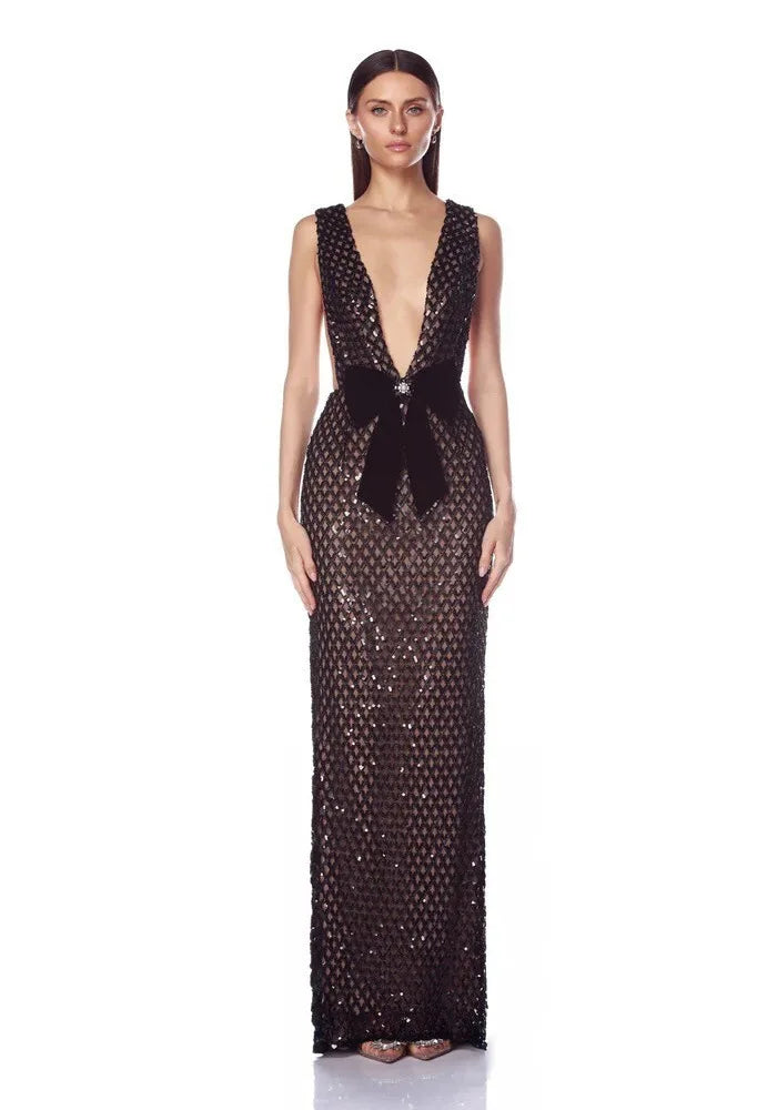 Model in a black sequined V-neck gown with a black velvet bow.