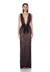 Model in a black sequined V-neck gown with a black velvet bow.