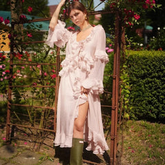 Woman in a pink dress standing outdoors with floral decorations