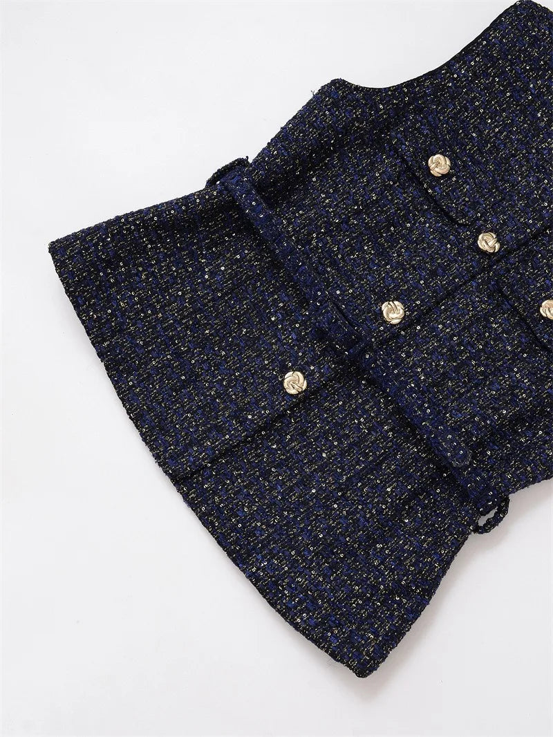 Close-up of a navy blue textured fabric with gold buttons on a white background