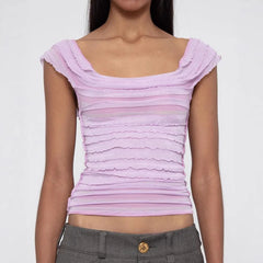 Woman wearing a light purple ruched top against a white background