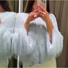 Person wearing a light blue fluffy cardigan taking a mirror selfie.
