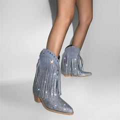 Silver glittery fringe boots worn by a person on a light gray background