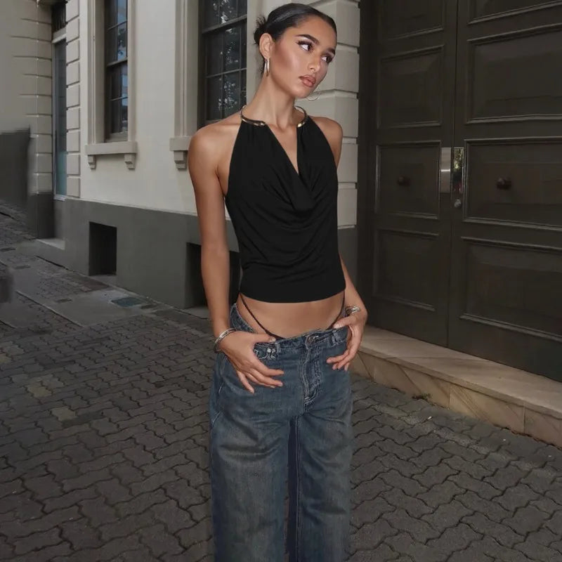 Woman in black top and blue jeans standing on a street