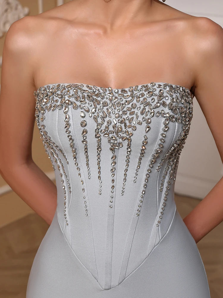 Silver strapless gown with intricate beading on a neutral background