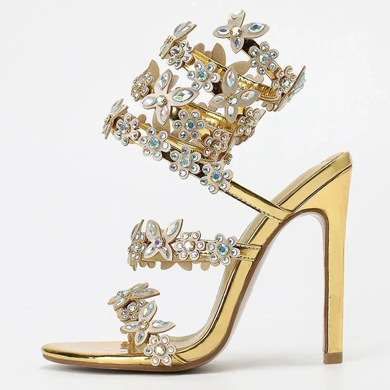 Gold high-heeled shoe with intricate gemstone embellishments on a white background