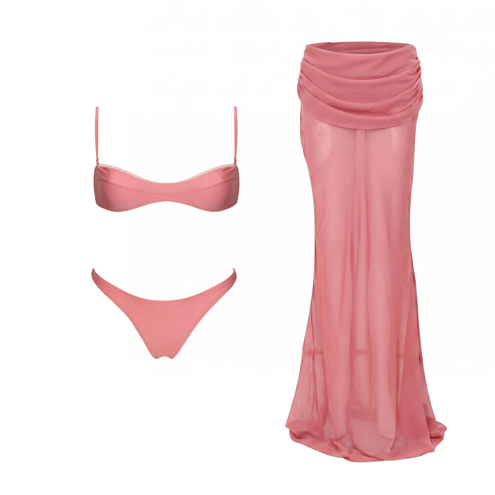 Pink ribbed bikini top and bottoms next to a pink sheer draped maxi skirt