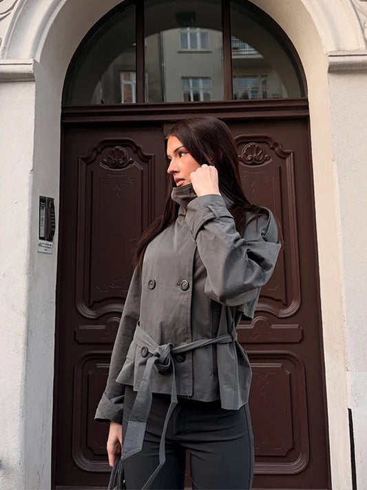 Grey belted double-breasted trench coat worn by a woman