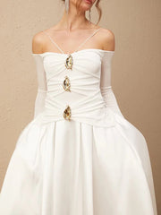 White wedding dress with gold embellishments on a beige background