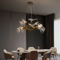 Modern chandelier hanging above a dining table in a stylish room with dark walls and curtains.