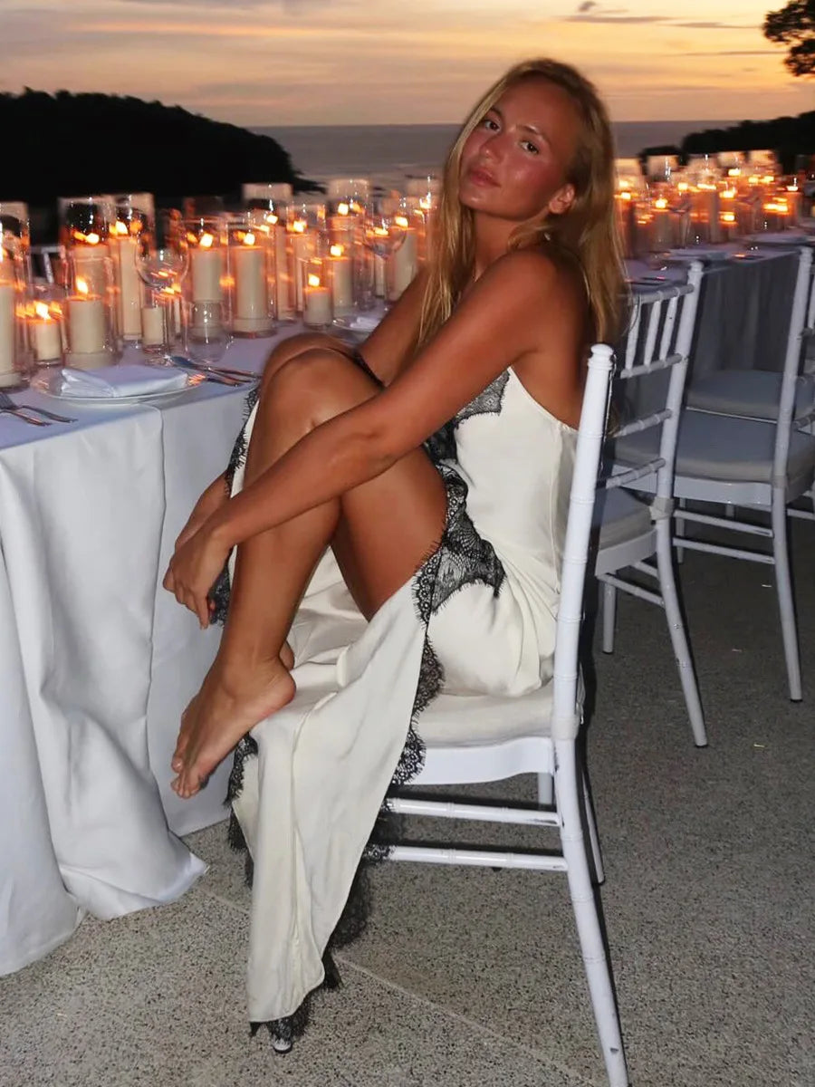 Woman sitting on a chair at an outdoor event with candles and tables in the background