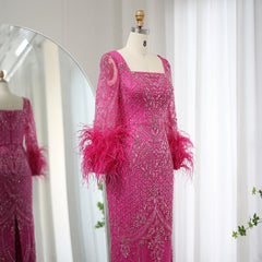 Mannequin displaying a glamorous fuchsia evening gown with delicate feather embellishments and long sleeves. Golden Atelier 4