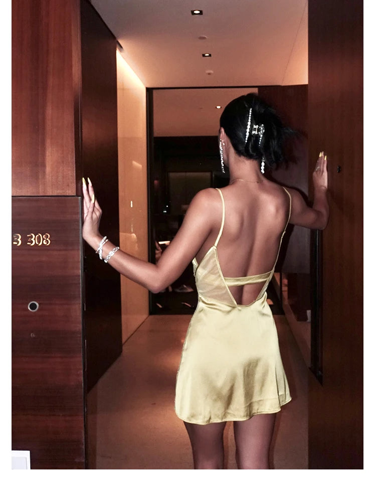 Woman in a yellow dress standing in a hallway with wooden doors.