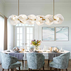 A luxurious dining room showcasing a modern glass petal chandelier as the centerpiece. B